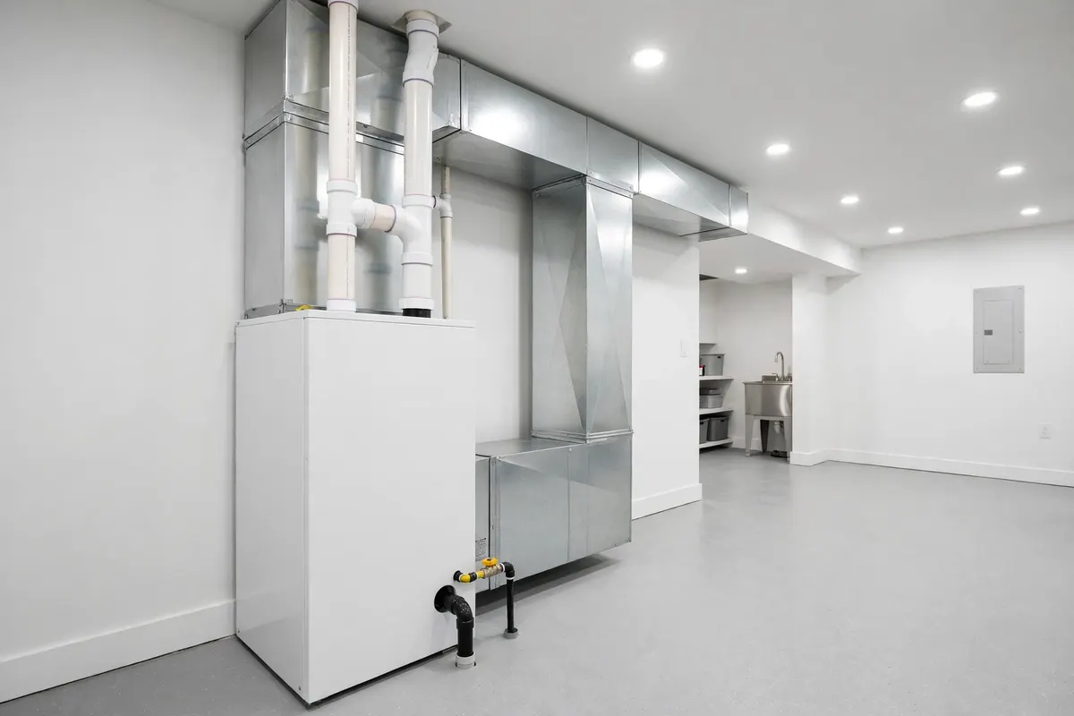 A new clean furnace installed in a bright modern basement utility room